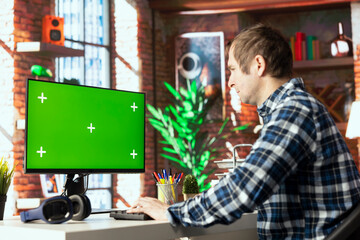 Worker at desk completing spreadsheets on mockup computer, entering numerical data into cells,...