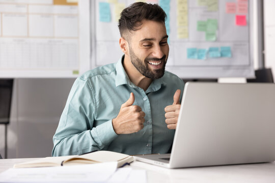 Smiling Latino man participate video call with colleague, showing thumbs-up as gesture of approval of idea, suggestion, or decision, provide positive feedback, give encouragement or acknowledgement