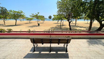 Obraz premium Outdoor beach, sands, trees, water, garden wooden bench in Hong Kong Repulse Bay