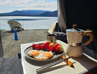 Landscape photography from tent with breakfast food, strewberry, egg, tomato, coffee