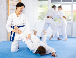 Multinational athletes paired up woman in sparring practice elbow strike with wrist grip on...