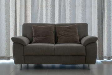 A modern, minimalist interior with a 2 seater sofa and natural accents. Isolated Sofa