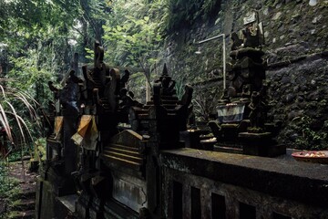 Balinese Hindu shrines, covered in moss, stand in a lush jungle setting in Ubud, Bali, Indonesia....