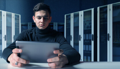 IT specialist using tablet in server room, monitoring network systems and performing diagnostics....