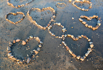 Stones on the beach laid out by lovers in the shape of hearts