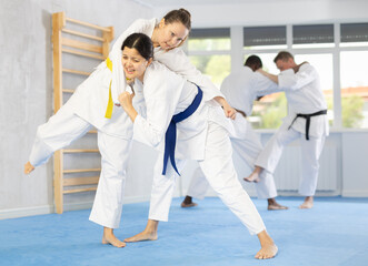 Cosmopolite sportsmen during classes, training improve and practice wrestling with opponent in...