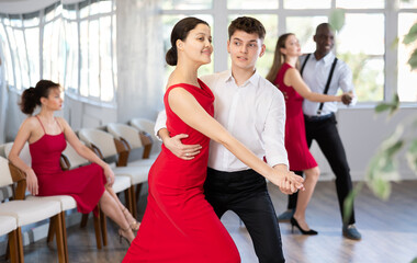 During rehearsal of reporting concert, man and Asian woman participants of dance workshop perform...