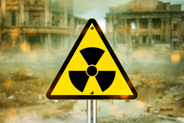 Radiation hazard warning sign in front of abandoned, ruined buildings in a contaminated danger...