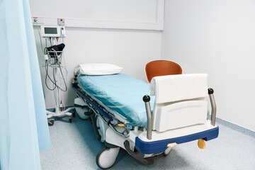 Empty Hospital Bed With Blue Sheet And Monitor