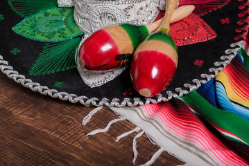 Maracas, serape and Mexican hat on wooden table. Mexican background.