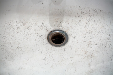 Pieces of mustache and beard in washbasin or sink after shaving