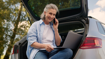 Successful Caucasian aged senior woman female older mature businesswoman browsing laptop typing...