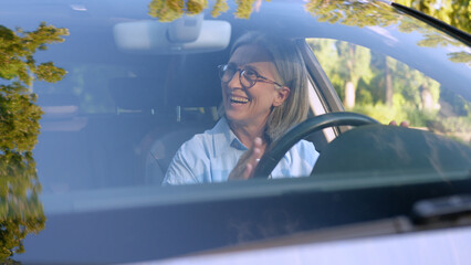 Laughing cheerful Caucasian elderly business woman car taxi driver auto owner mature businesswoman...