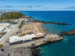 An aerial view of Puerto del Carmen, Lanzarote, showcasing coastal buildings and clear blue waters