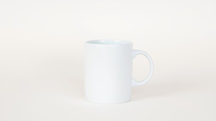 Obraz premium A simple white ceramic mug with a handle sitting on a white surface in a bright studio setting