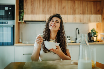 Young caucasian woman eating cereals for breakfast at home	