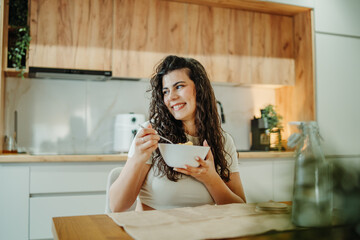 Young caucasian woman eating cereals for breakfast at home	