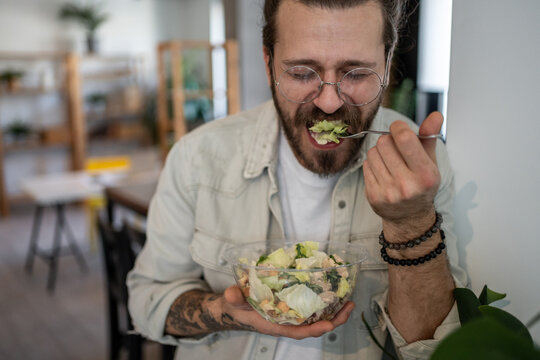 Office worker enjoying healthy caesar salad during lunch break