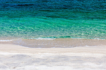 Crystal-clear emerald colored sea wave touches awesome pristine sandy beach. Koh Adang, Thailand. Sea background.