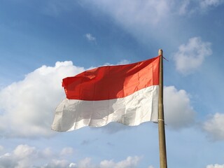 The red and white flag of the Republic of Indonesia is flown on a bamboo pole