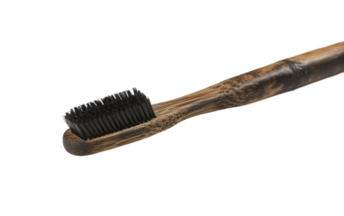 Eco-friendly bamboo toothbrush with activated charcoal bristles promoting environmentally conscious dental health isolated on transparent background PNG
