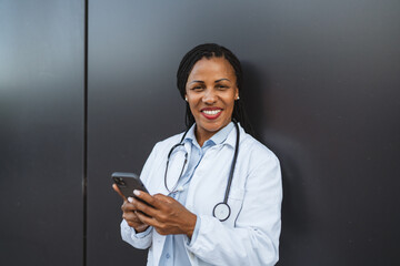 african american woman doctor use cellphone in front black background