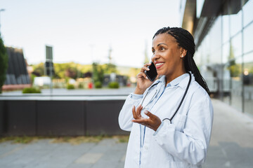 woman doctor stand on the street talk to a patient on a mobile phone