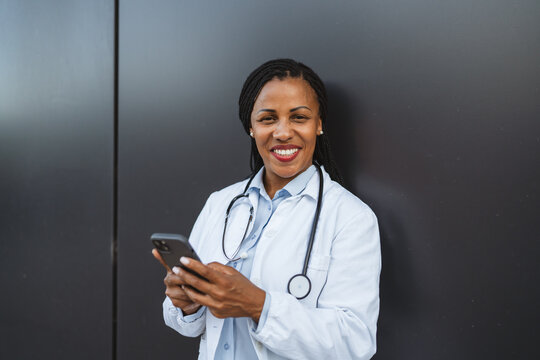 african american woman doctor use cellphone in front black background