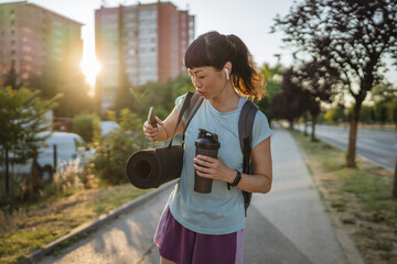 japanese woman drink protein shake and use mobile phone go to training