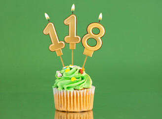 Number 118 birthday candle - Cupcake on a green background