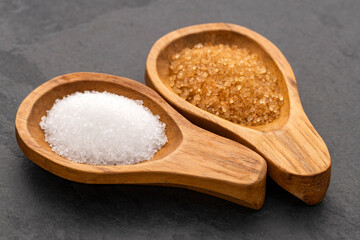 White sugar and brown sugar in spoons - Saccharum officinarum