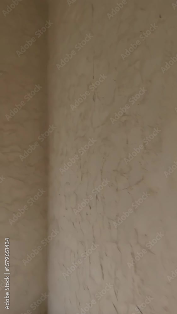 Aufkleber close-up vertical view of a neutral beige painted wall with textured surface, showing rough plasteri