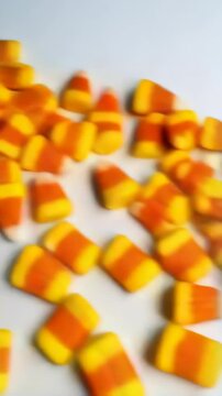 Candy corn pieces arranged on a white background, creating a festive autumn or Halloween design with plenty of negative space.