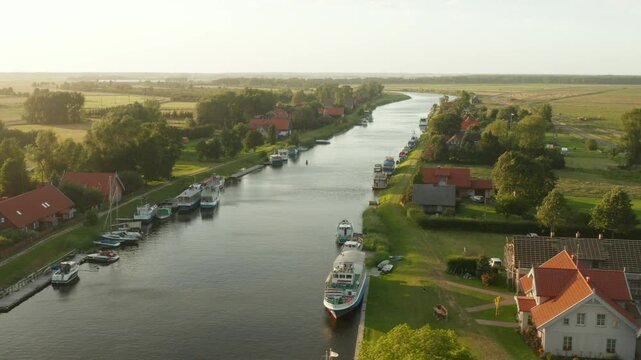Drone footage captures the charming symmetry of Mingės houses lined up along the Minija River