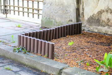 Autumn leaves scattered on concrete steps beside modern wooden fence with vertical slats