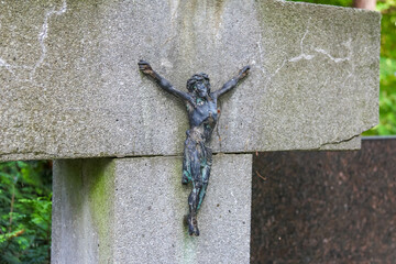 Bronze crucifix sculpture mounted on stone memorial creating powerful religious symbol