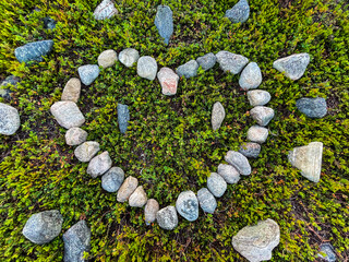 Stones arranged in the shape of a heart on moss-covered forest ground. A natural symbol of love,...