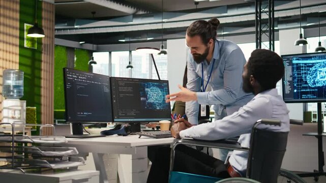 Manager supervising developer with paraplegia writing code, developing deep learning APIs. Supervisor overseeing work done by IT expert in wheelchair troubleshooting software errors using AI, camera A