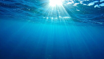 Obraz premium Sunlight Streaming Through Deep Blue Ocean Waters Creates Abstract Light Beams