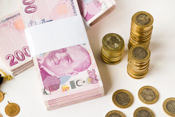 Turkish Lira Banknotes with stacked coins on white background.