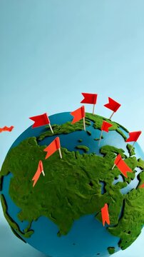 Conceptual world globe with green landmasses and numerous small red flag markers scattered over continents and oceans