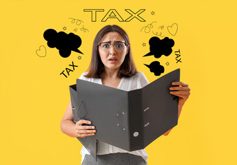 Young afraid woman with folders on yellow background