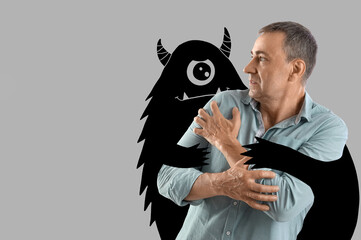 Mature man having panic attack on light background
