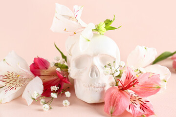 Human skull with beautiful lily flowers on pink background