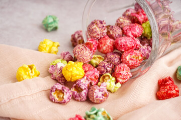Glass with sweet colorful popcorn on white background