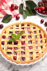 Tasty cherry pie and berries on white marble table, closeup