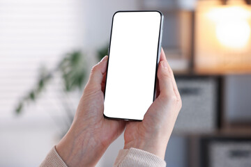 Woman using modern smartphone at home, closeup