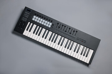 One portable MIDI keyboard on grey background, top view