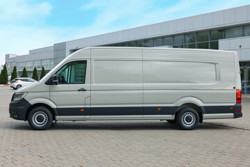 One white minibus parked on paved road outdoors