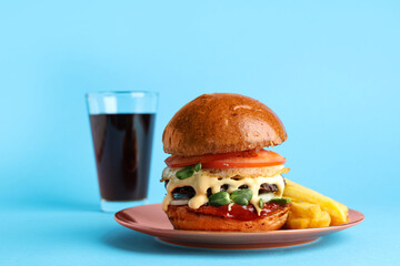 Plate with tasty burger, french fries and glass of cola on blue background